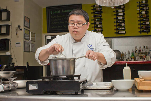 Chef Dennis Chan cooking in the Blue Bamboo Kitchen