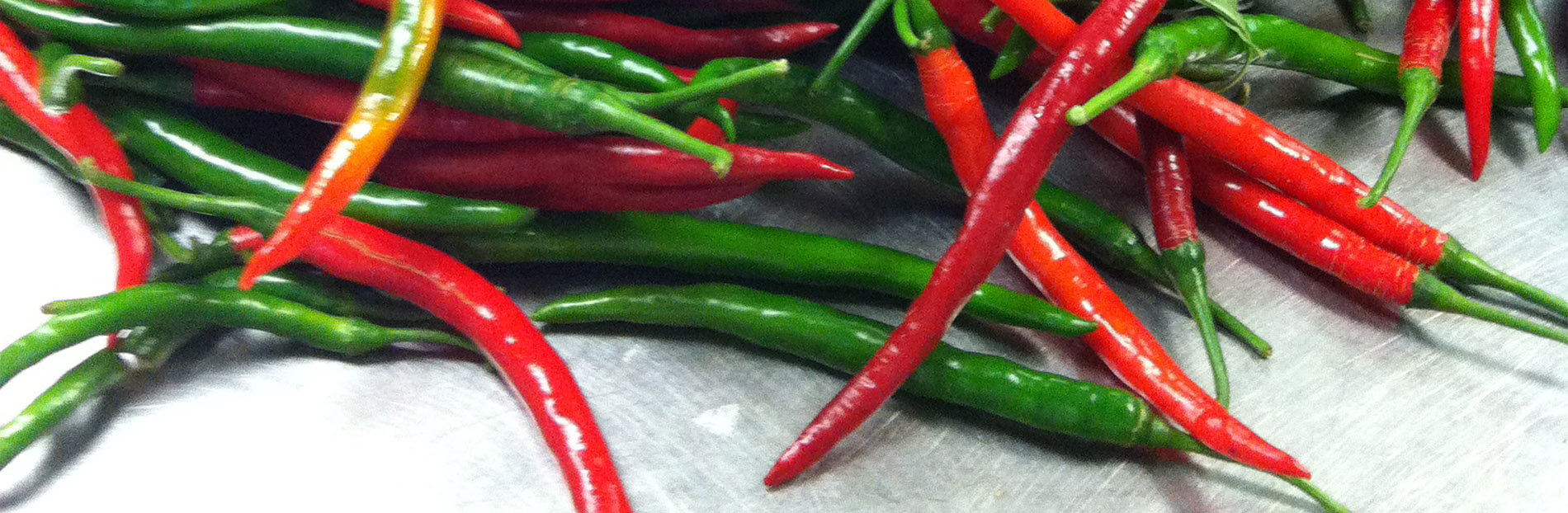 Pile of green and red hot peppers